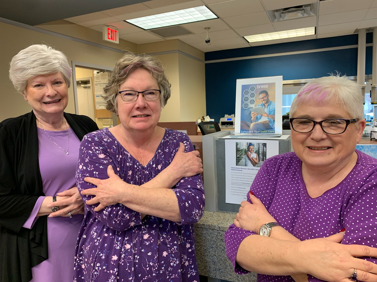 Three women in purple standing together.